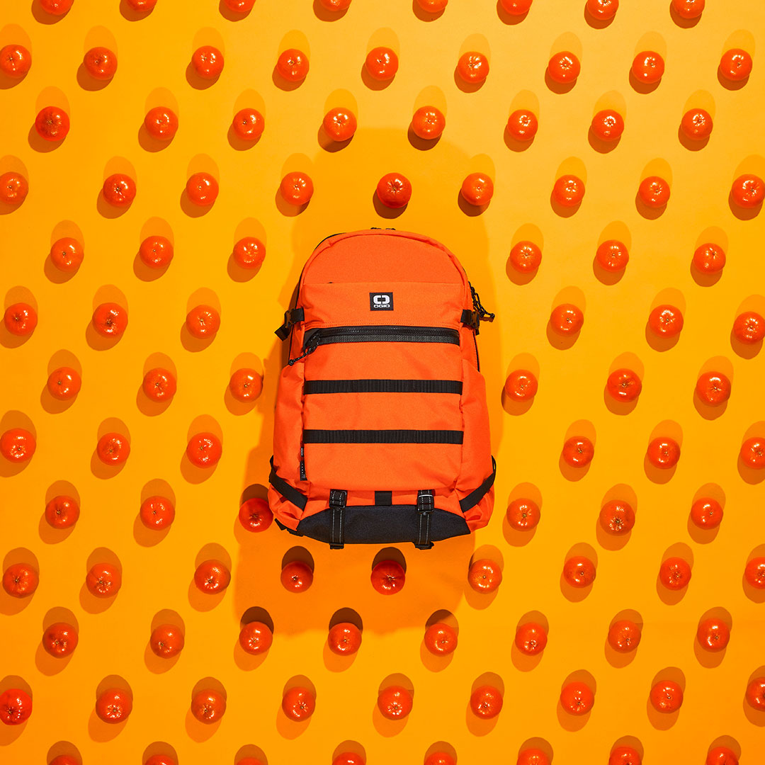 OGIO Glow Orange Color Introduction social photo. Orange Backpack with oranges all around it.